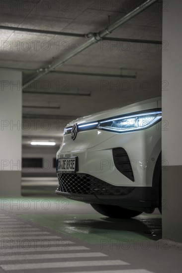 A car in an underground garage with headlights on at night, VW ID4 electric car, Deer Carsharing,