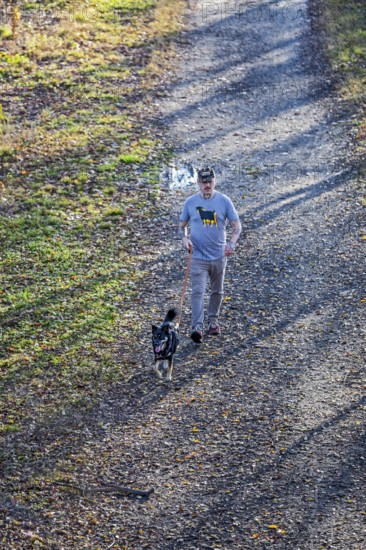 Washington, DC - A man walks his dog on the Kingman Island Trail. Kingman Island is in the