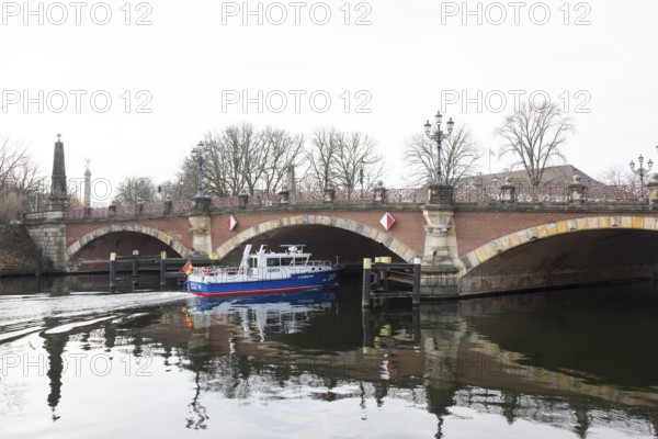 A water protection police ship sails under the Luther Bridge near Bellevue Palace on the Spree in