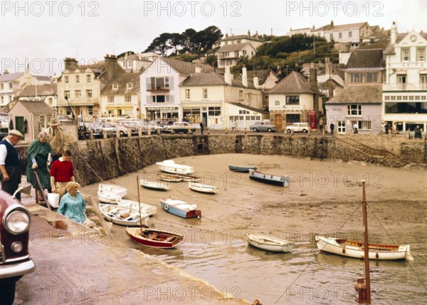 Historic waterfront buildings, boats at low tide in harbour at St Mawes, Cornwall, England, UK, c