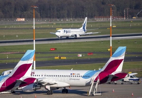 Boeing 737-400 of Bulgarian airline GP Aviation Limited landing, Eurowings aircraft parked in