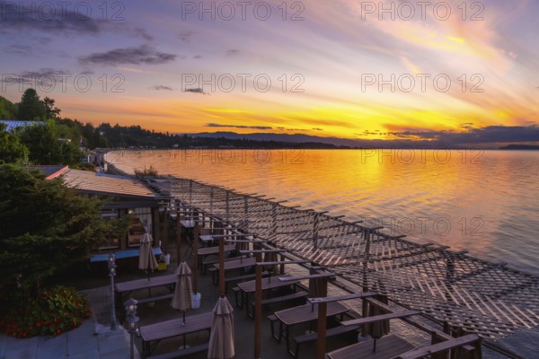 Golden sunset illuminating calm bay waters while reflecting vibrant evening sky colors over a