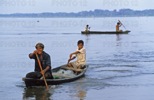 Father and son in a paddle boat on the Amazon near Iquitos, Peru, South America, September 1997,