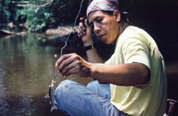 Man caught fish to be used as bait for piranhas, Rio Yanayacu, Amazon region near Iquitos, Peru,
