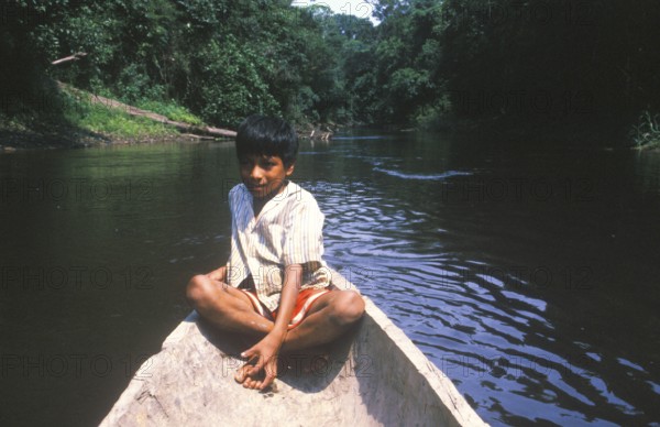 Little boy in a canoe, Rio Yanayacu, Amazon region near Iquitos, Peru, South America, September