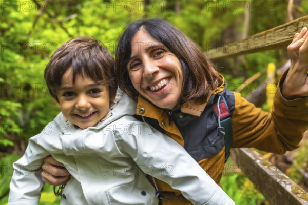 Mother and son are enjoying a hike in a lush rainforest, sharing a happy moment together surrounded