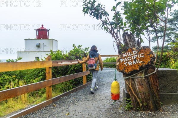 Female tourist walking along the gravel path of the wild pacific trail near amphitrite point