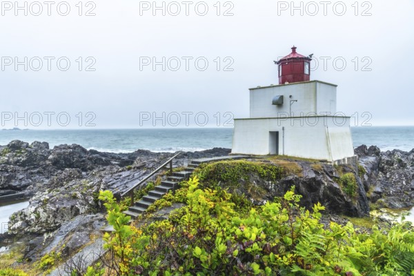 The amphitrite point lighthouse stands on the rocky coast of ucluelet, vancouver island, providing