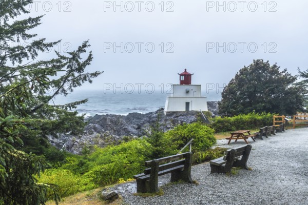 Amphitrite point lighthouse rising on the rocky ucluelet coast of vancouver island, british