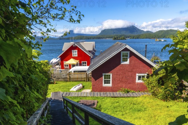 Wooden stairs leading down to red houses in tofino, british columbia, canada with clayoquot sound