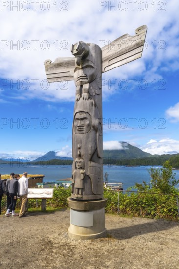 Wooden totem pole standing on a base overlooking the harbor in tofino, british columbia, canada,