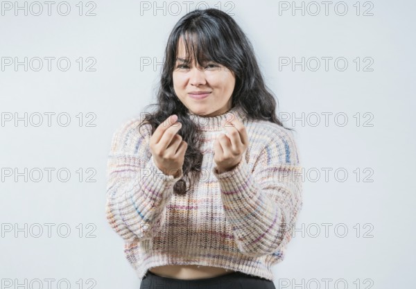 Cunning woman rubbing fingers showing money gesture isolated. Asian girl rubbing fingers asking for