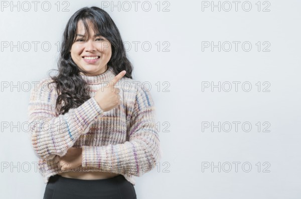 Beautiful asian woman pointing and presenting something, isolated. Cheerful asian girl pointing at