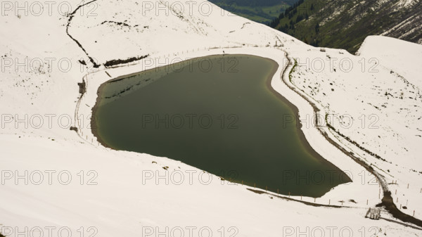 Another onset of winter in May, Riezler Alpsee, an artificially created lake, snow pond, feeds the