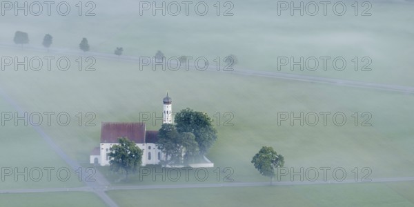 St. Coloman pilgrimage church in front of sunrise in autumn fog, Königswinkel, Ostallgäu, Allgäu,