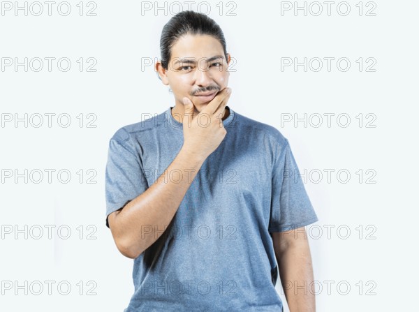 Pensive person rubbing chin with doubtful expression. Thoughtful young man rubbing his chin looking