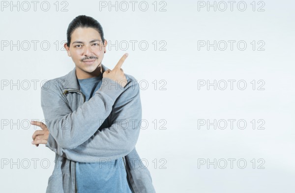 Latin guy pointing an advertising to side isolated. Smiling people pointing a banner on blank space