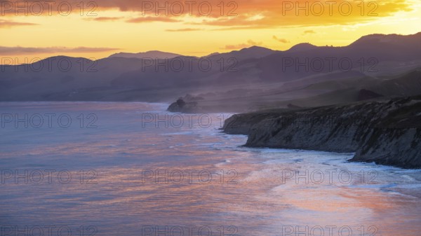 Wairarapa coast at sunset. Sea, mountains, backlight. Castlepoint, Wairarapa Coast, Wellington