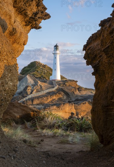 Castlepoint lighthouse on a rock, sea, sunrise. Castlepoint, Wairarapa Coast, Wellington Region,
