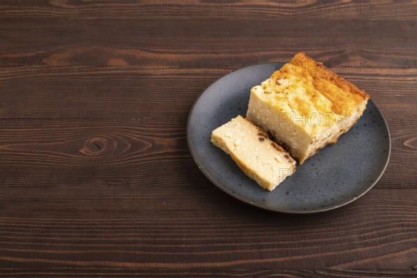 ?ottage cheese ?asserole, Curd cake, with dried apricots and raisins on brown wooden background,