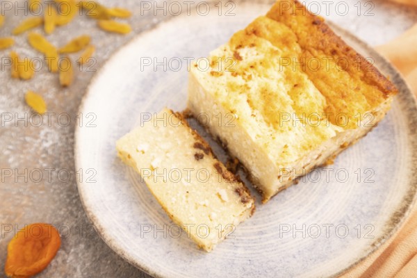 ?ottage cheese ?asserole, Curd cake, with dried apricots and raisins on brown concrete background