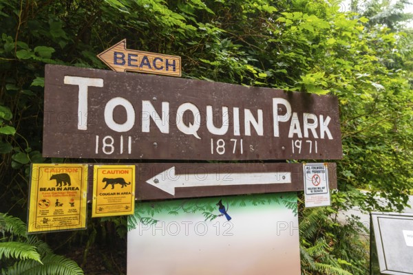 Wooden sign indicating tonquin park with directions to the beach and warnings about bears and