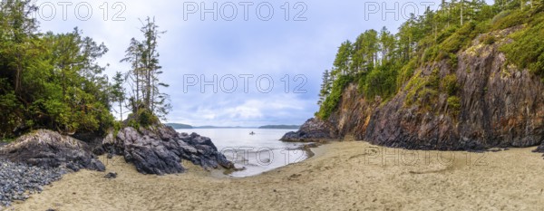 Panoramic view of a secluded beach and inlet in tofino, vancouver island, featuring dramatic rock