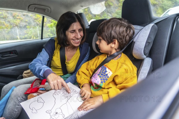 Mother and son sharing joyful moments during a road trip, reading a colorful children's book