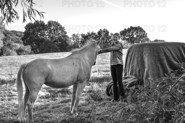 Young girl with her white horse in the pasture, black and white, Othenstorf, Mecklenburg-Western