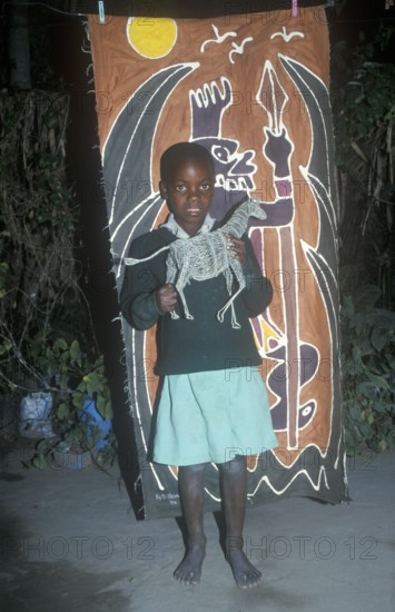 Child with homemade artwork in a self-help project in Chitungwiza near Harare, Zimbabwe, Africa,