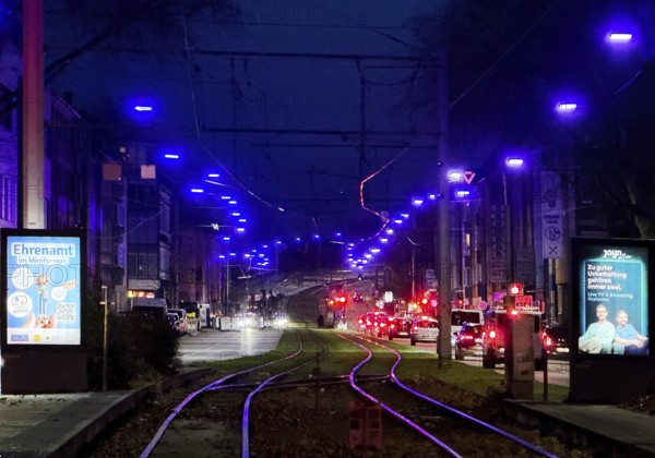 The blue light strip shines into the dark sky above Kurt-Schumacher-Straße in Schalke,