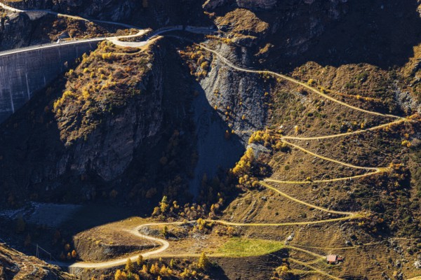 A hiking trail leads up to the dam of the Lac de Moiry reservoir, Val d'Anniviers, Valais Alps,