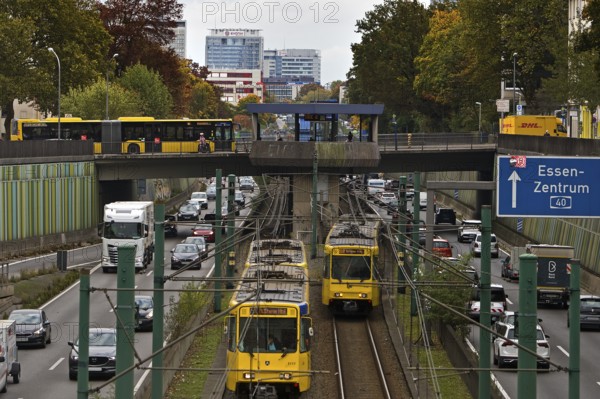Lots of traffic on the A 40 motorway on four lanes and two subways on two lanes and a bus on the
