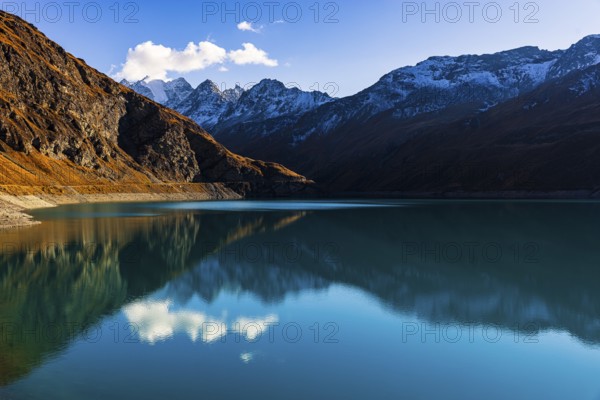 The turquoise Lac de Moiry reservoir, behind the peaks of the Grand Cornier, Tete Blanche and