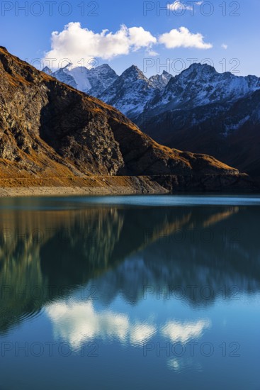 The turquoise Lac de Moiry reservoir, behind the peaks of the Grand Cornier, Tete Blanche and