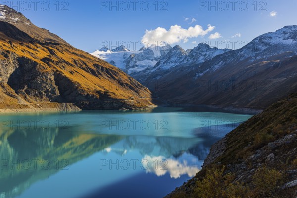 The turquoise Lac de Moiry reservoir, behind the snow-capped peaks of the Grand Cornier, Tete