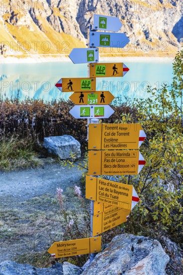 Information boards on trails for hikers and mountaineers, in the back the Lac de Moiry reservoir,
