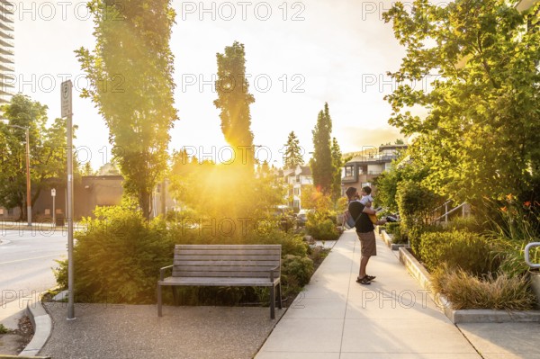 Father enjoying quality time with his baby while strolling through a vibrant vancouver park,