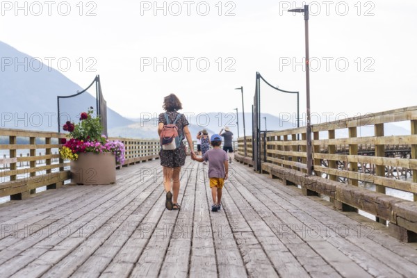Mother and son enjoying a leisurely stroll along a picturesque wooden pier in salmon arm, british
