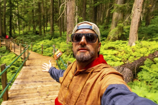 Hipster tourist taking a selfie while walking and showing the hemlock grove boardwalk in an ancient
