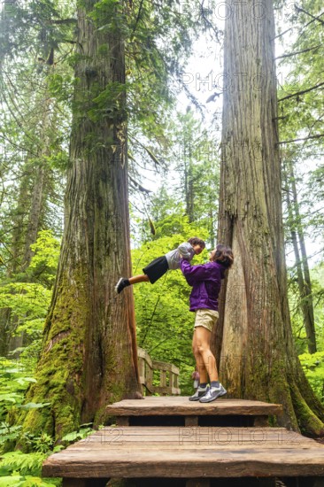 Mother and son sharing a joyful moment on the giant cedars boardwalk trail, surrounded by majestic
