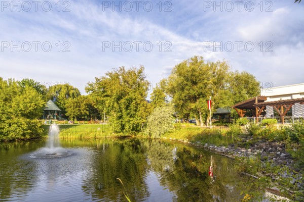 Tranquil pond with a fountain in a public park in salmon arm, british columbia, canada, surrounded