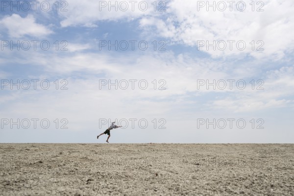 Abstract, man jumping on the Etosha pan, salt pan, Etosha National Park, Namibia