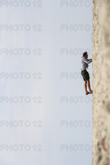 Symbolic picture, abstract, man climbing on wall, rotated image, on the Etosha pan, salt pan,