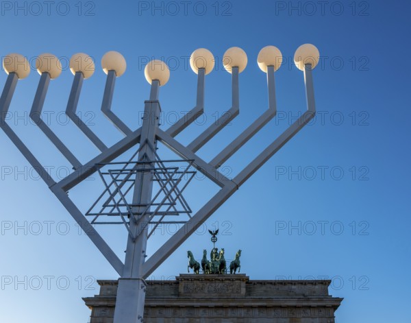 Large Hanukkah chandelier at the Brandenburg Gate in daylight, sign of lively Jewish life, symbolic