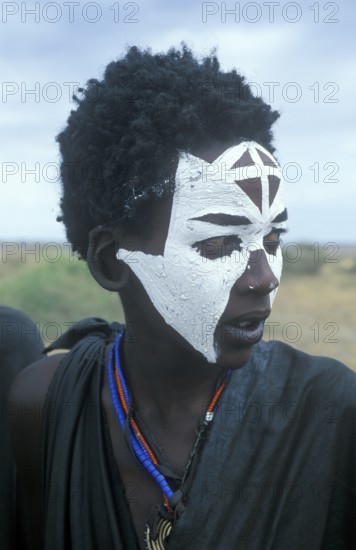 Portrait of a Maasai boy with face painted white on the occasion of his initiation, Ngorongoro