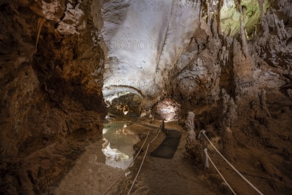 Stalactites and stalagmites, reflection in a small underground lake, rock formations in a