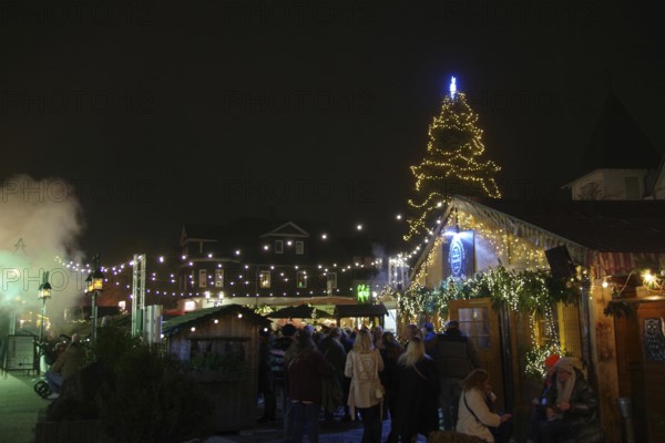 A festive Christmas market at night with glowing lights and a decorated Christmas tree, Winterberg,