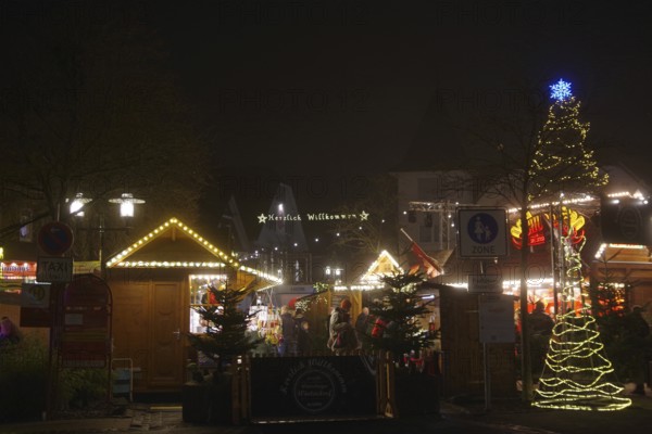An atmospheric Christmas market in the dark with festively decorated huts and trees, Winterberg,