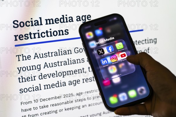 In this photo illustration, a person holds a smartphone displaying popular social media apps in